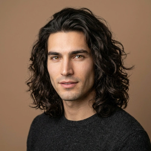 A 27-year-old man with stylish mid-long wavy hair in a professional studio portrait.